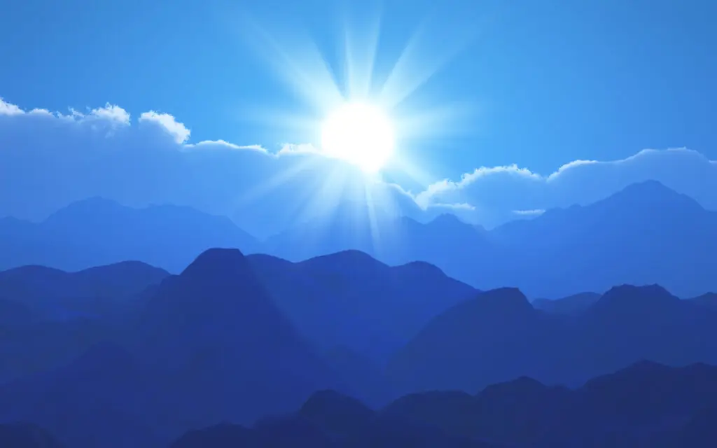 a sun shining over mountains
